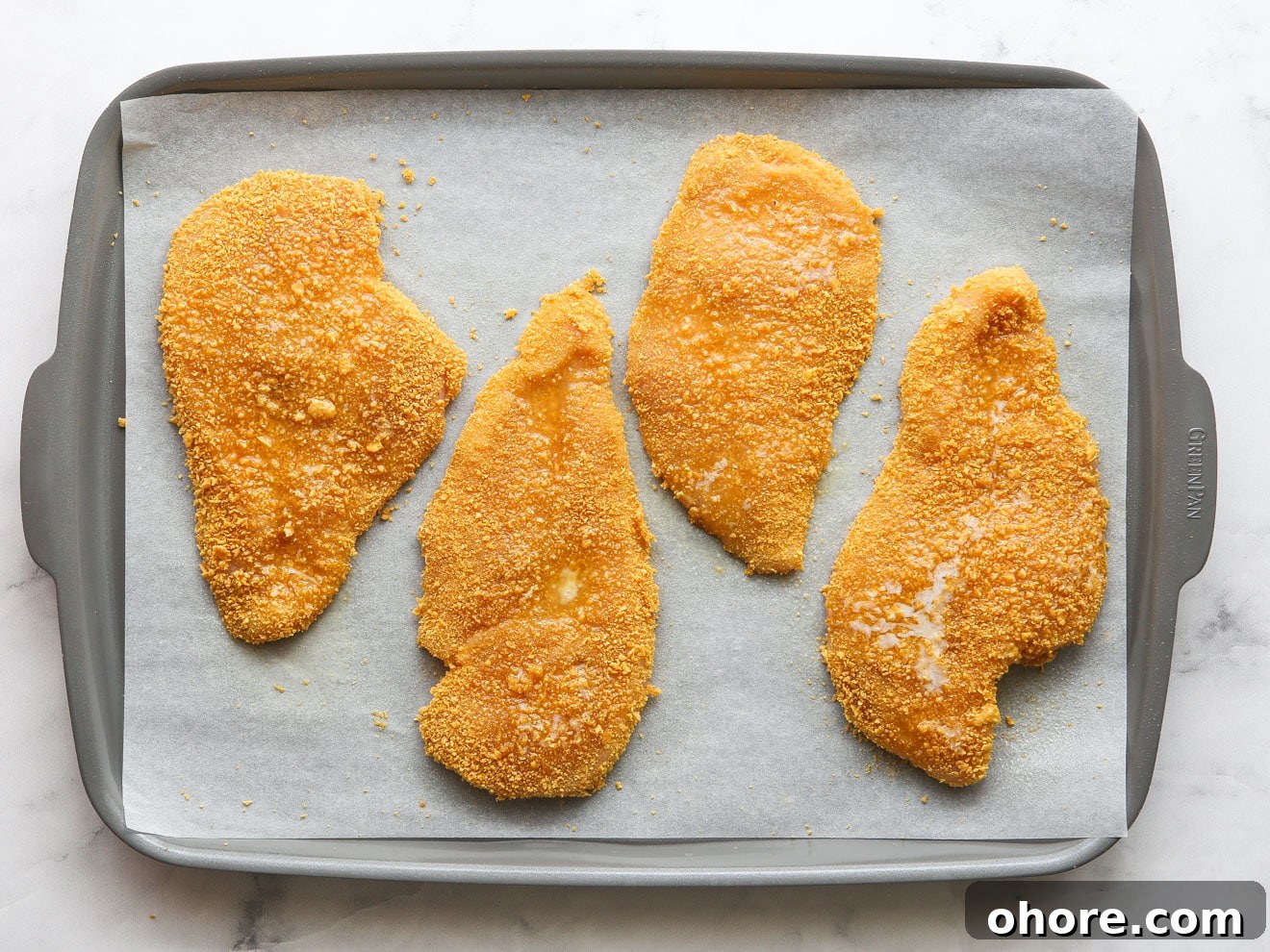 chicken ready for the oven on a sheet pan