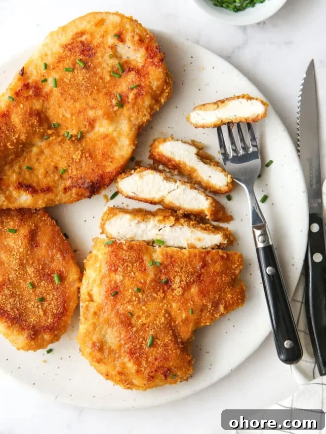 Crispy Oven-Fried Chicken Recipe: Juicy, Golden, and Tender 10 plate of oven fried chicken with slices and a fork and knife