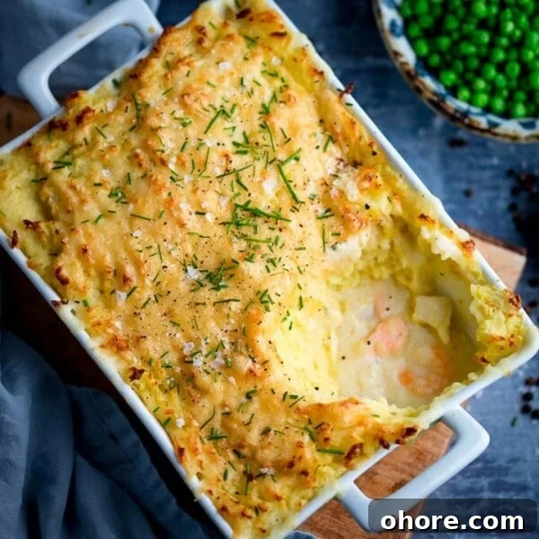 Fish pie with mashed potato in a white rectangular dish - scoop taken out
