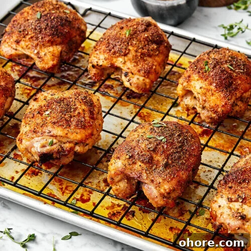 Baked chicken thighs on a sheet pan.