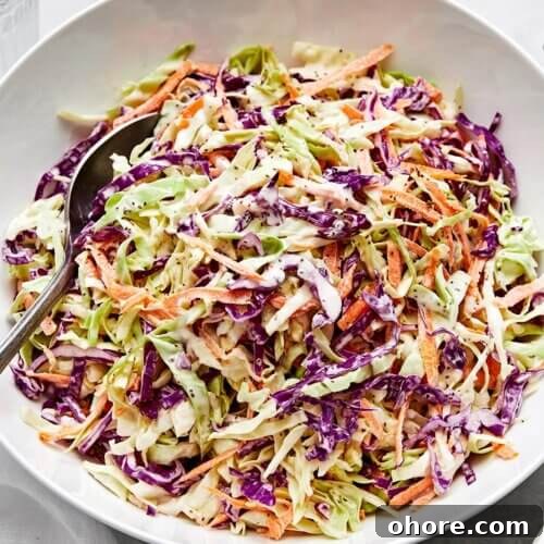 A white bowl of creamy coleslaw.