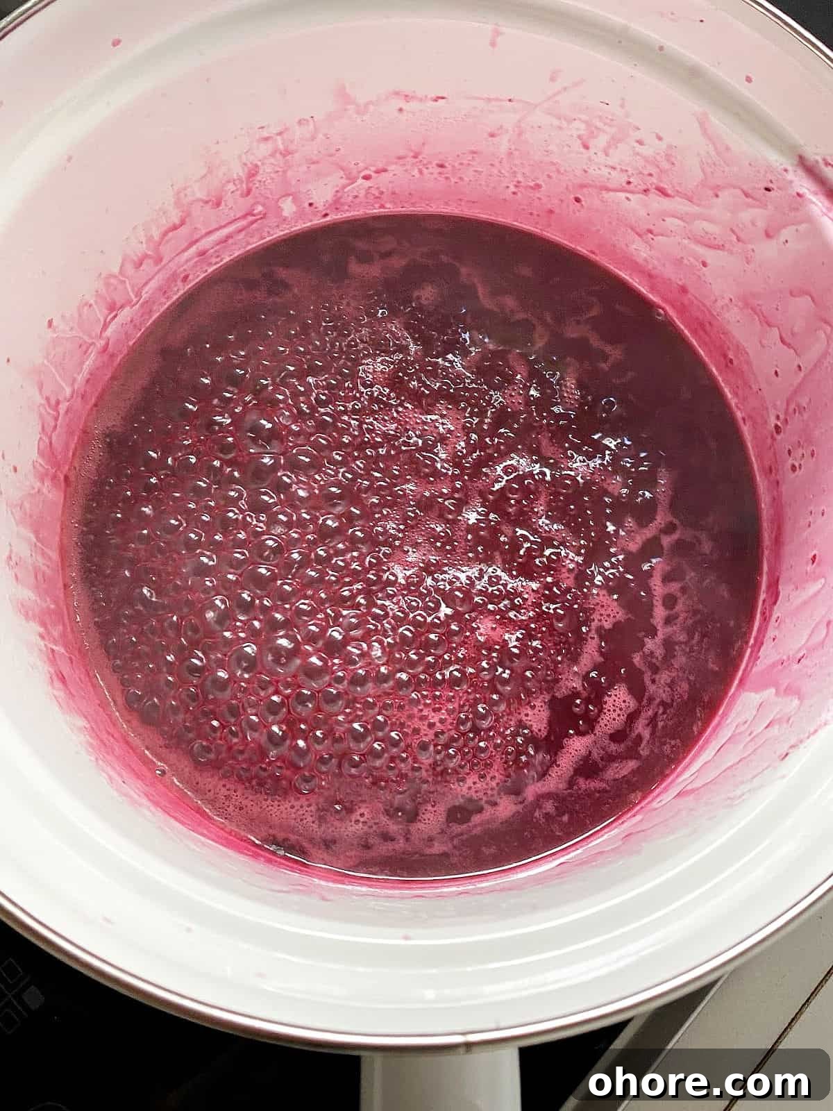 Blueberry Compote Recipe: Simple Homemade Blueberry Sauce 6 Simmering blueberry juice in a white saucepan.