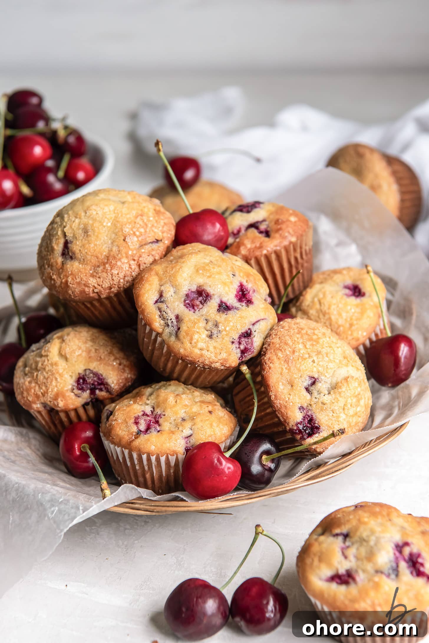 Cherry Almond Muffins: Homemade Cherry Muffin Recipe with Almond Extract 6 pile of cherry muffins with a few fresh cherries on a shallow basket