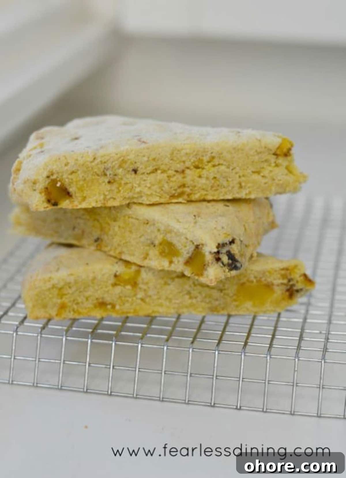 Three gluten free cornmeal scones stacked on the counter.