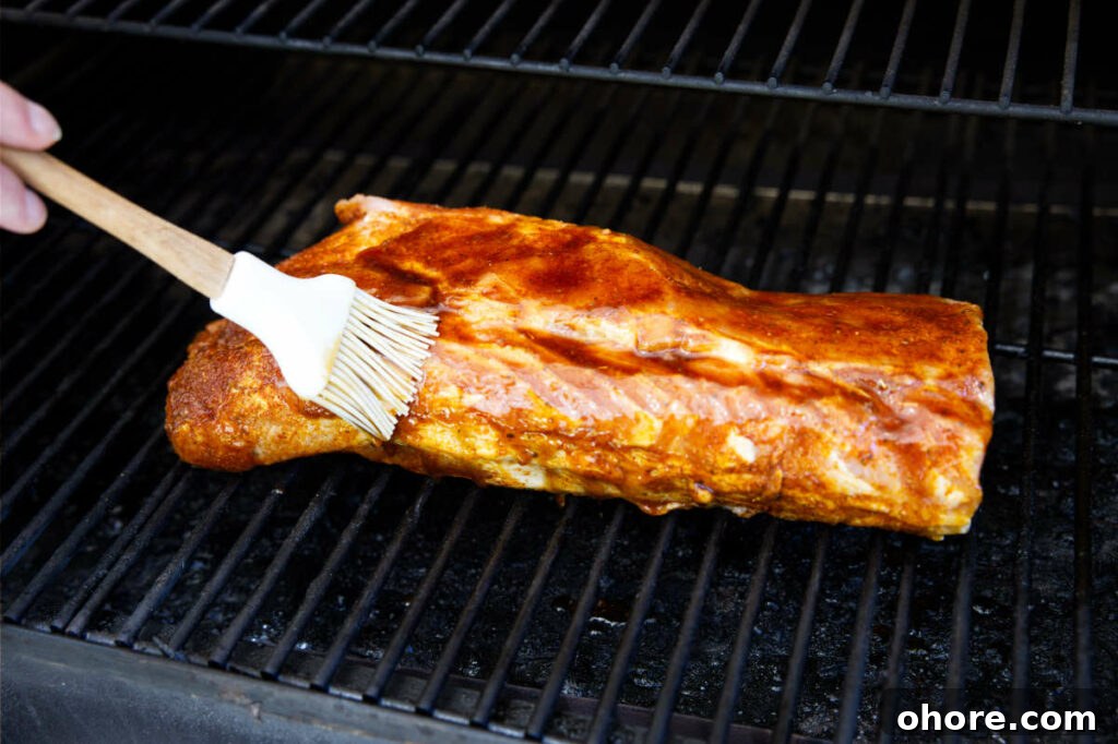 Juicy Smoked Pork Loin Recipe for Tender, Flavorful Results 11 brushing the glaze on the pork loin