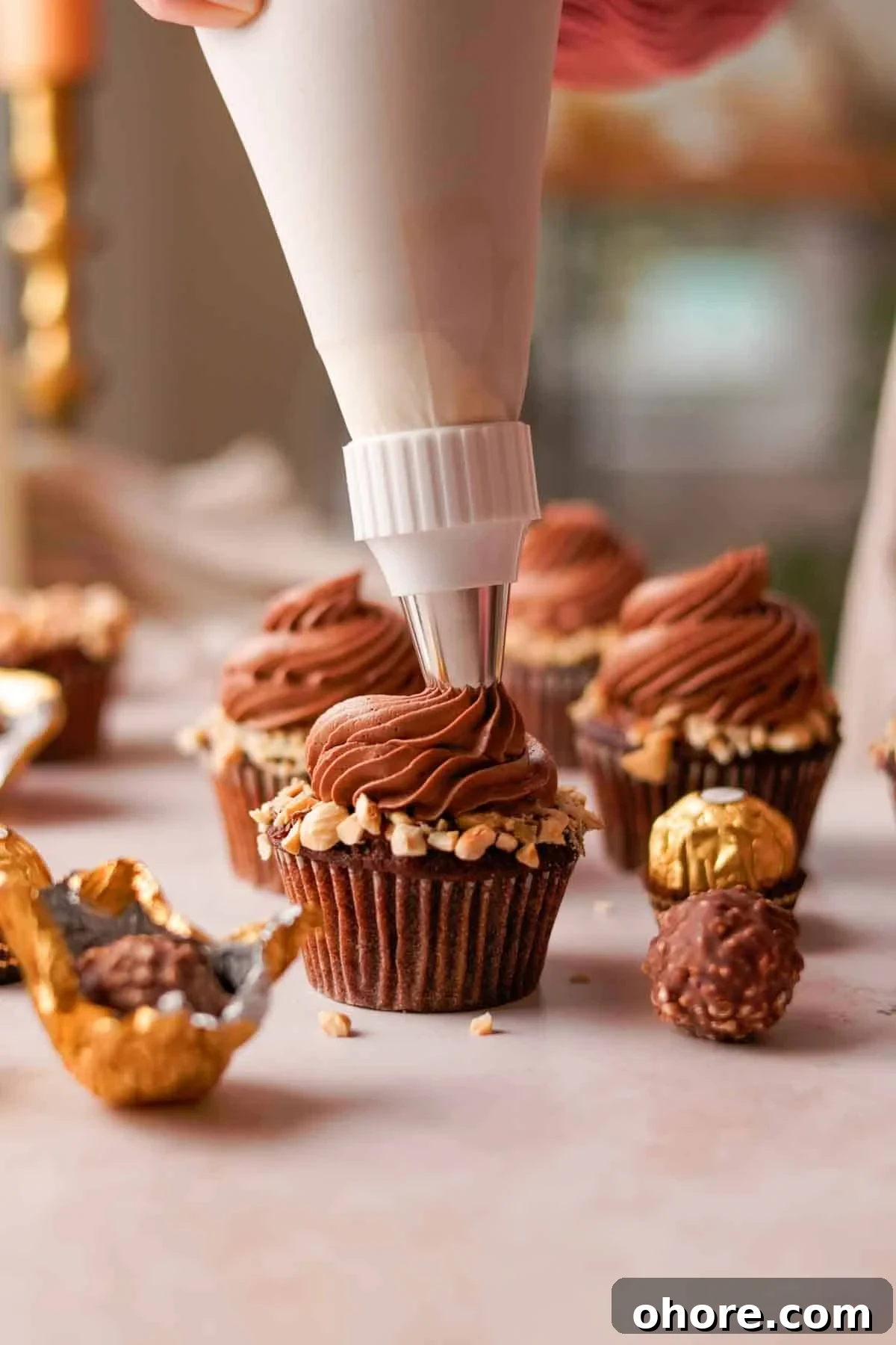 Ferrero Rocher Cupcakes Recipe: Decadent Hazelnut Chocolate Cupcakes 18 piping creamy nutella frosting on top of ferrero rocher cupcake