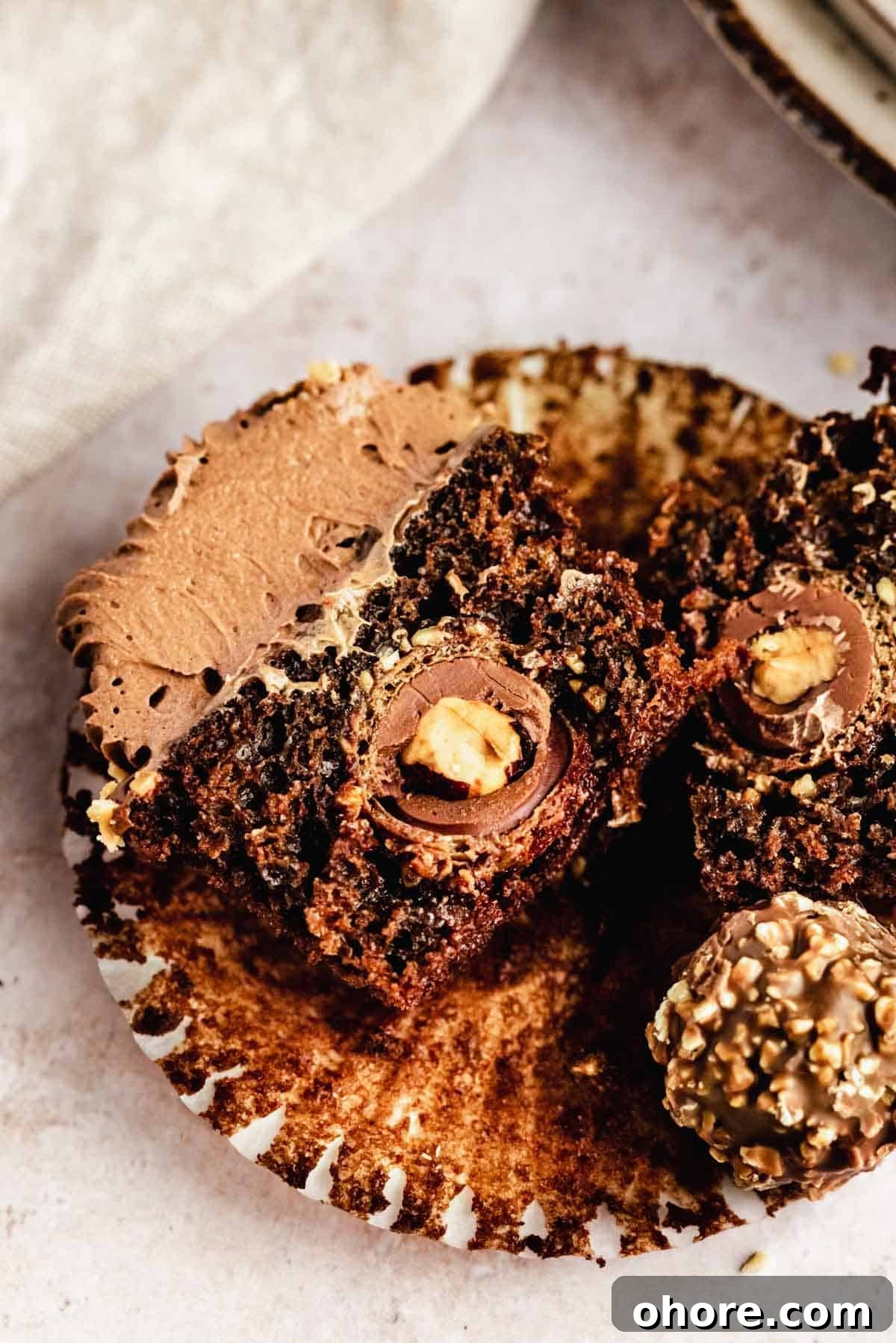 Ferrero Rocher Cupcakes Recipe: Decadent Hazelnut Chocolate Cupcakes 3 chocolate cupcake cut in half with ferrero rocher inside