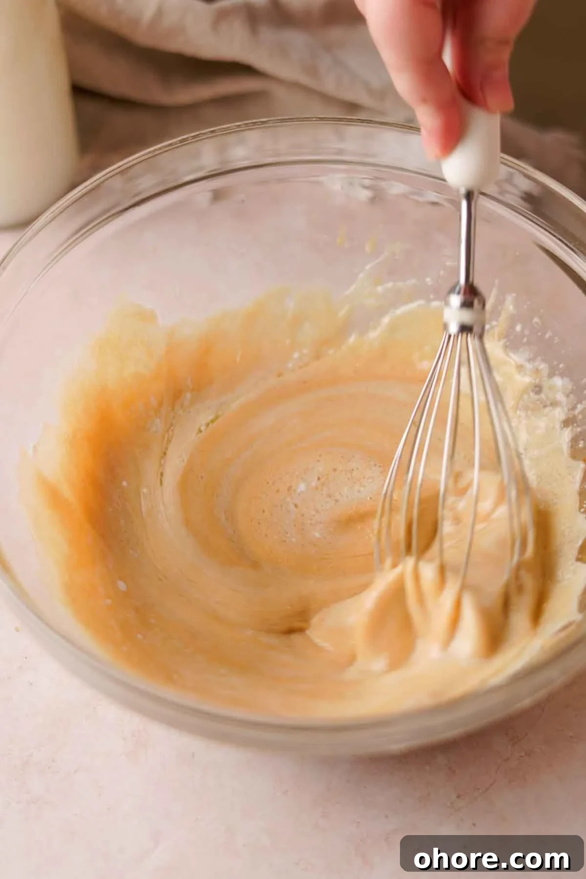 Ferrero Rocher Cupcakes Recipe: Decadent Hazelnut Chocolate Cupcakes 8 whisking wet ingredients for chocolate cupcakes in a glass bowl with a hand whisk