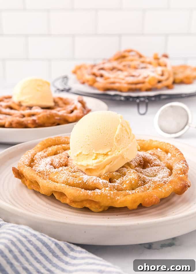 Crispy Homemade Funnel Cake Recipe for Fair-Style Treats 6 Homemade Funnel Cakes topped with powdered sugar.