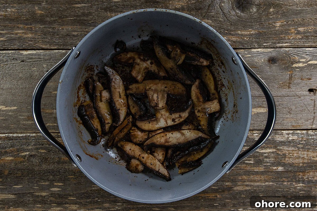 Keto Dutch Oven Pot Roast Recipe — Tender Low-Carb Roast 6 Sliced portobella mushrooms in the Dutch oven.