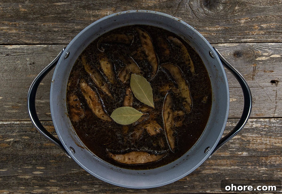 Keto Dutch Oven Pot Roast Recipe — Tender Low-Carb Roast 7 Beef broth and bay leaves added to pot.