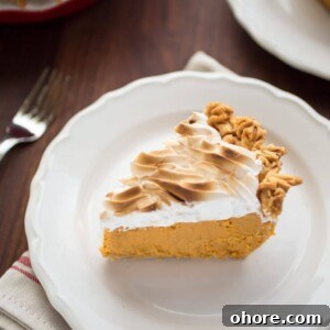 a slice of bourbon sweet potato pie with toasted marshmallow cream topping on a white plate