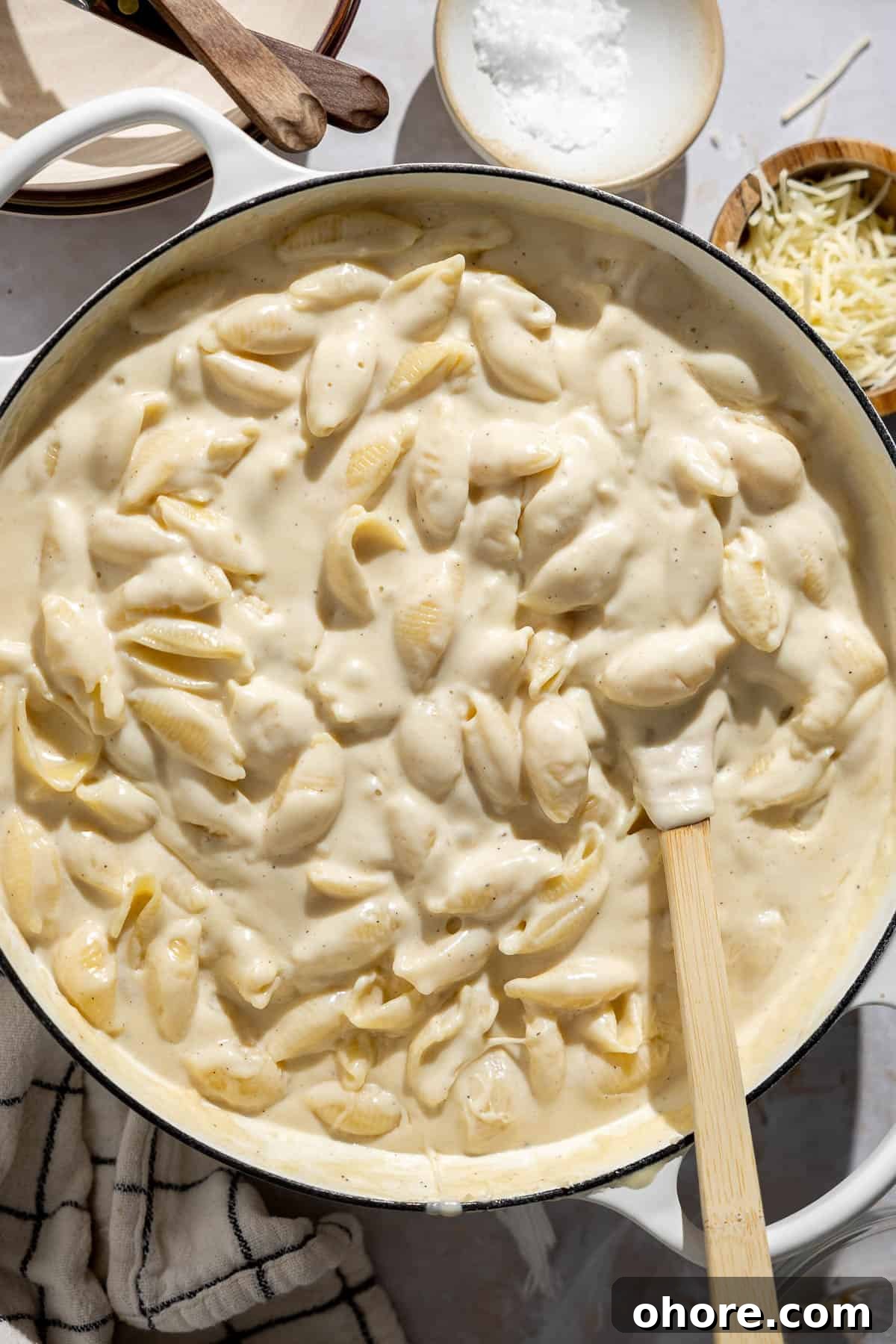 Creamy White Cheddar Macaroni and Cheese Recipe 3 creamy white cheddar mac and cheese in a skillet with a spatula.