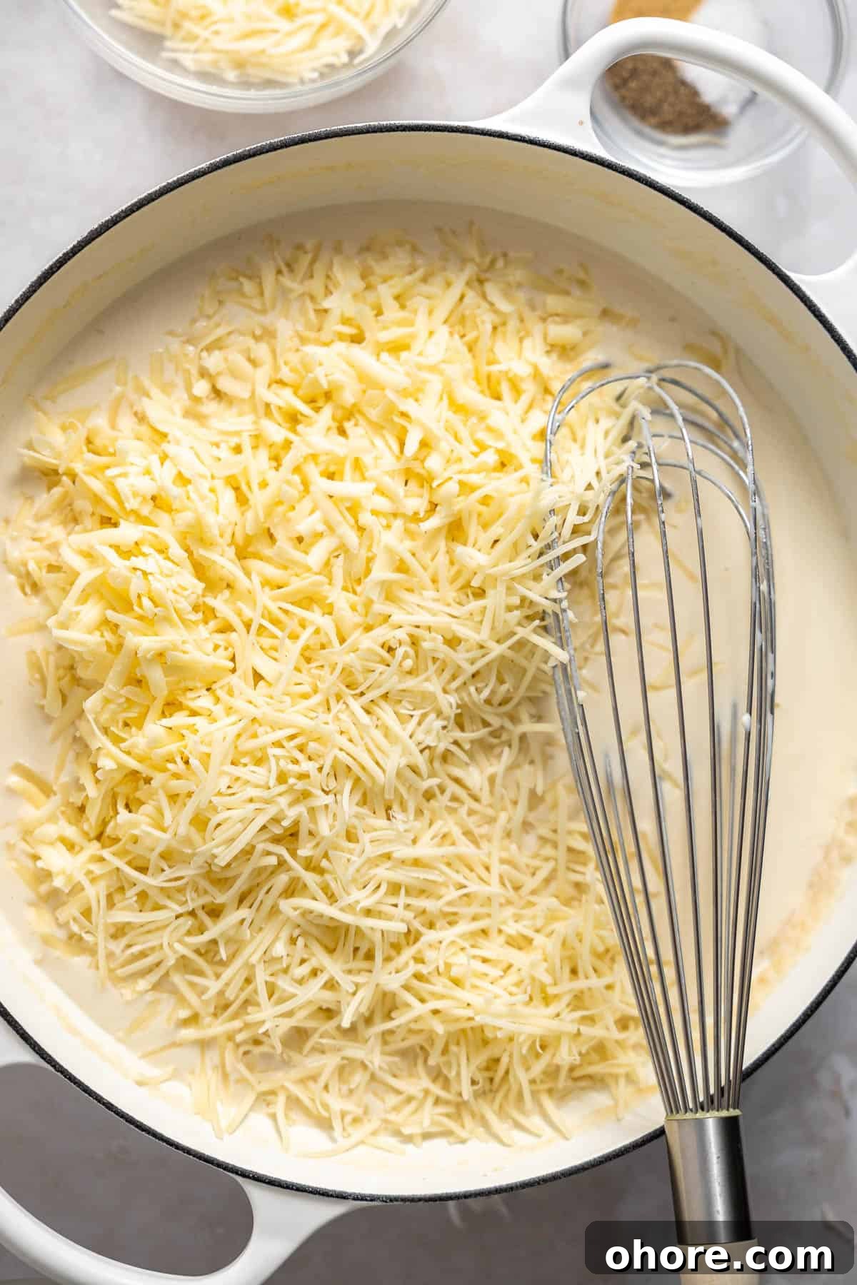 Creamy White Cheddar Macaroni and Cheese Recipe 6 shredded white cheese melting into mac and cheese sauce.