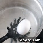 Perfect Jammy Eggs Recipe: Soft-Boiled Egg Guide 10 Carefully dropping an egg into the boiling water.