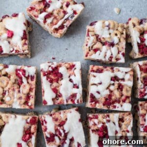 Raspberry coconut cereal treats on a blue surface.