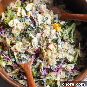 vegan caesar pasta salad with kale in a wooden serving bowl.
