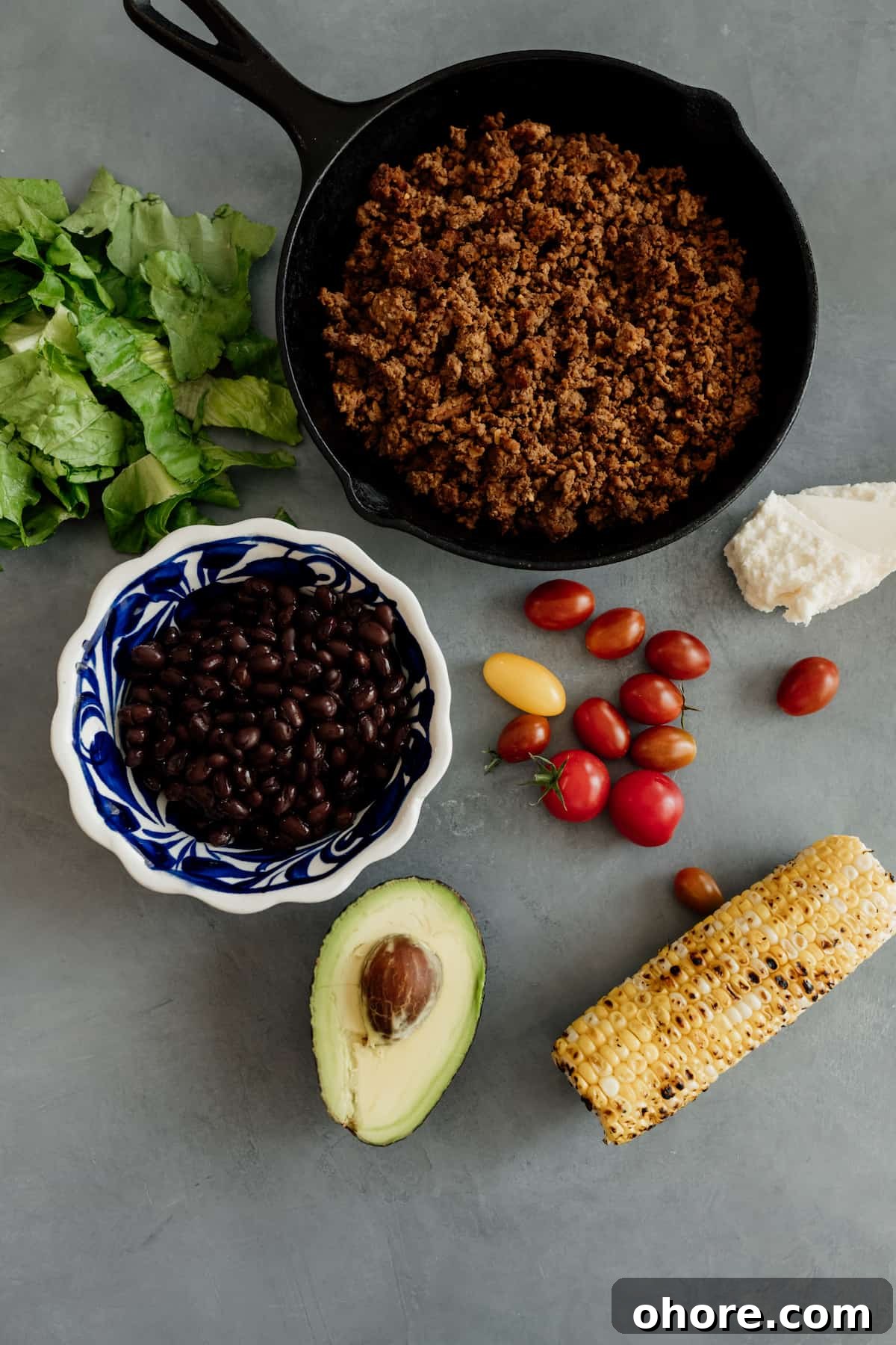 Crispy Taco Salad with zesty avocado lime dressing 3 skillet with ground bison and ingredients for a taco salad - corn, avocado, tomatoes, black beans