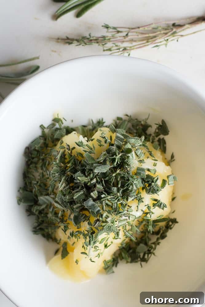 Spatchcocked Whole Turkey Smoked on a Traeger Grill 8 Chopped fresh herbs on top of softened ghee in a white bowl.