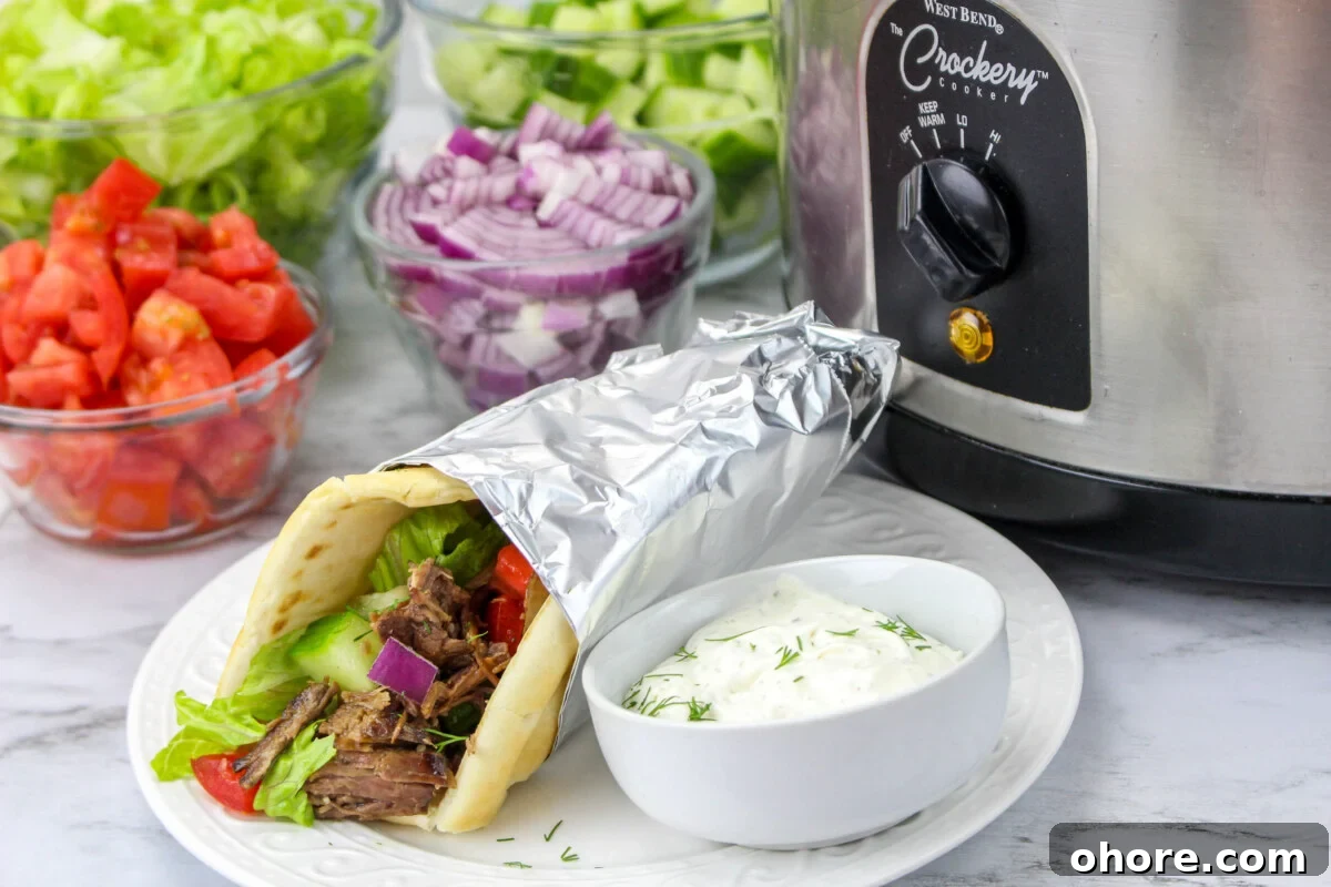 Slow Cooker Beef Gyros Recipe: Tender, Flavorful Greek Sandwiches 9 beef gyro wrapped in foil in front of slow cooker.