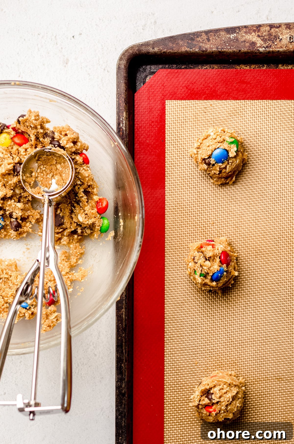 Ultimate Monster Cookie Recipe for Chewy, Loaded Cookies 13 monster oatmeal cookie dough balls on a baking sheet