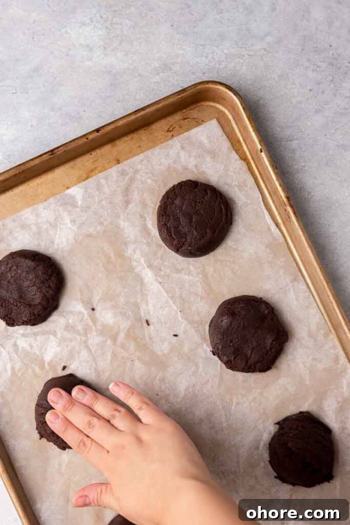 Hand flattening chocolate cookie dough