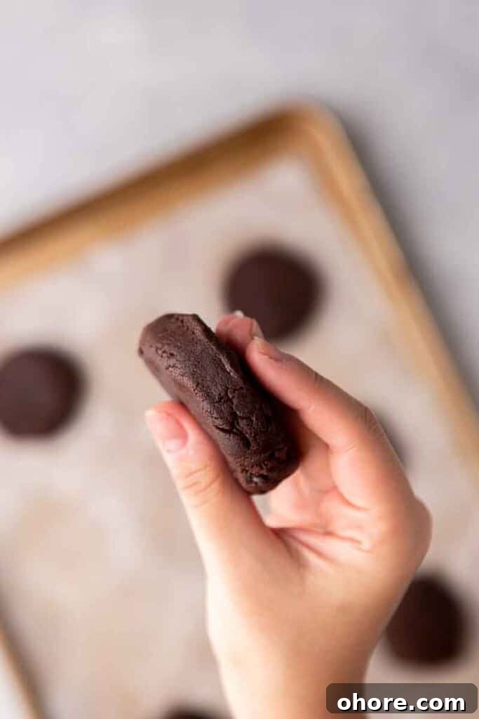 Hand flattening chocolate cookie dough