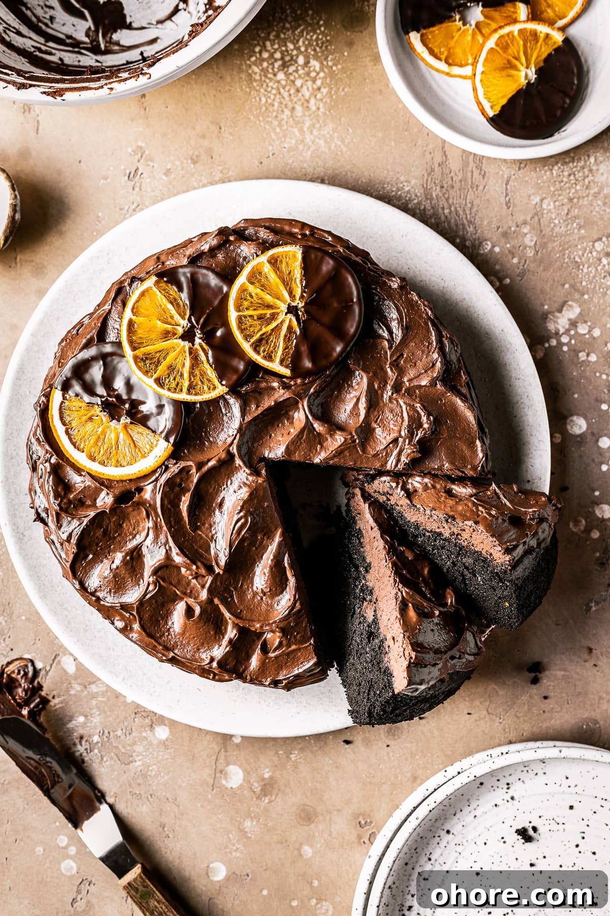 Decadent Chocolate Orange Cake Recipe for Irresistible Flavor 2 A chocolate cake with two slices cut and tipped revealing the dark interior and fudgy chocolate frosting.