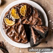Decadent Chocolate Orange Cake Recipe for Irresistible Flavor 11 A chocolate cake with two slices cut and tipped revealing the dark interior and fudgy chocolate frosting.