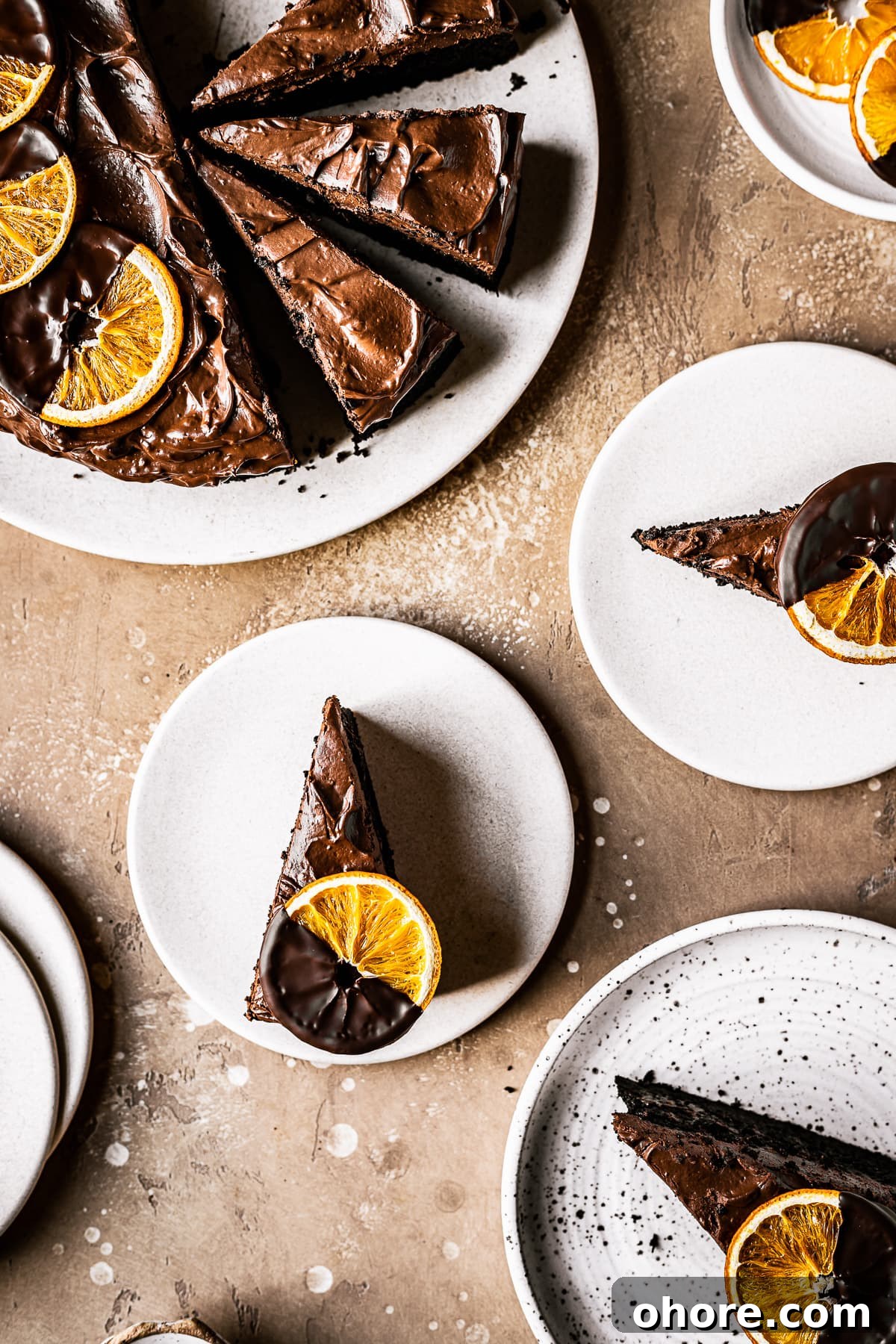 Decadent Chocolate Orange Cake Recipe for Irresistible Flavor 6 Sliced chocolate orange cake on plates topped with chocolate dipped dried orange slices.