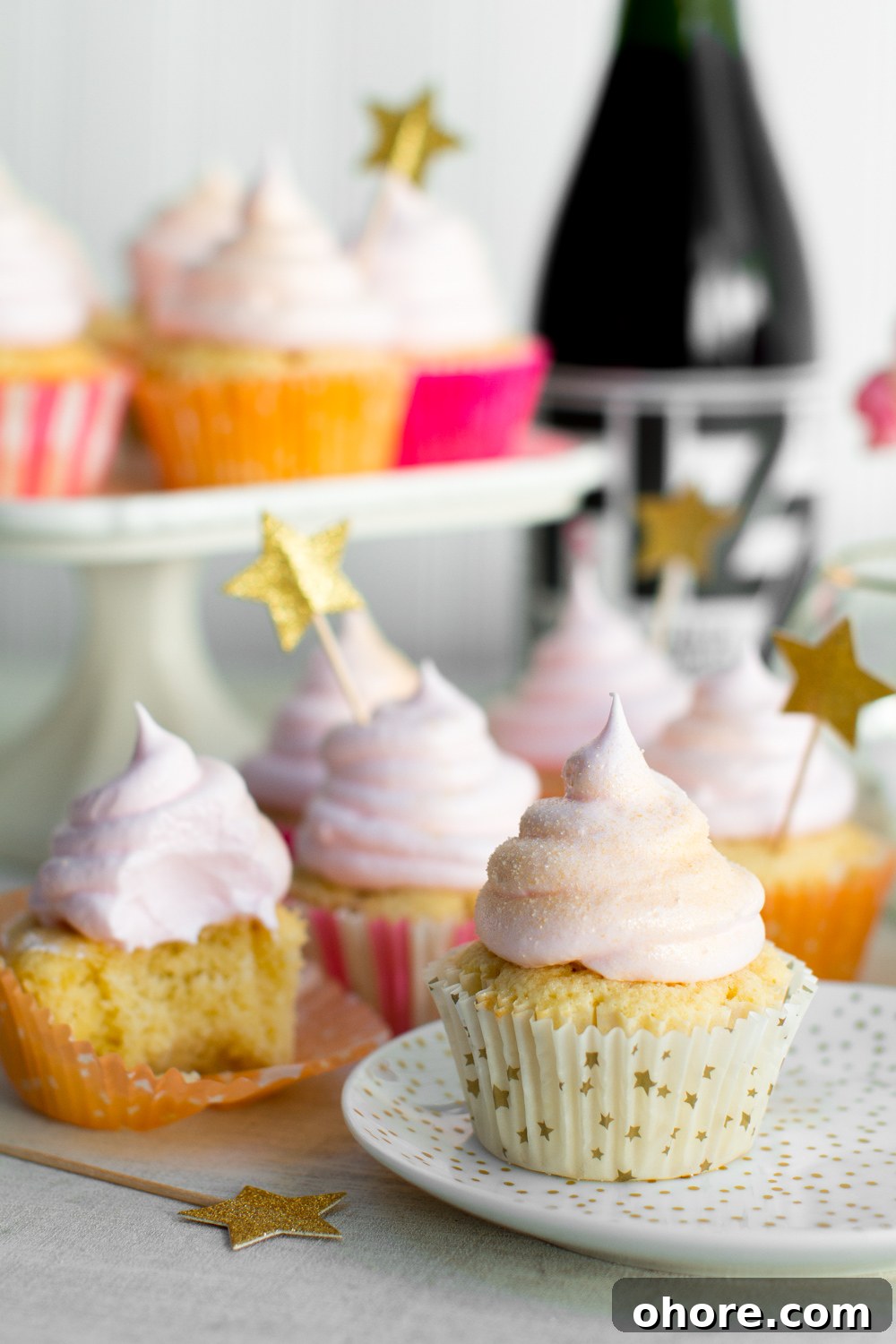 Champagne Meringue Cupcakes next to a bottle of champagne