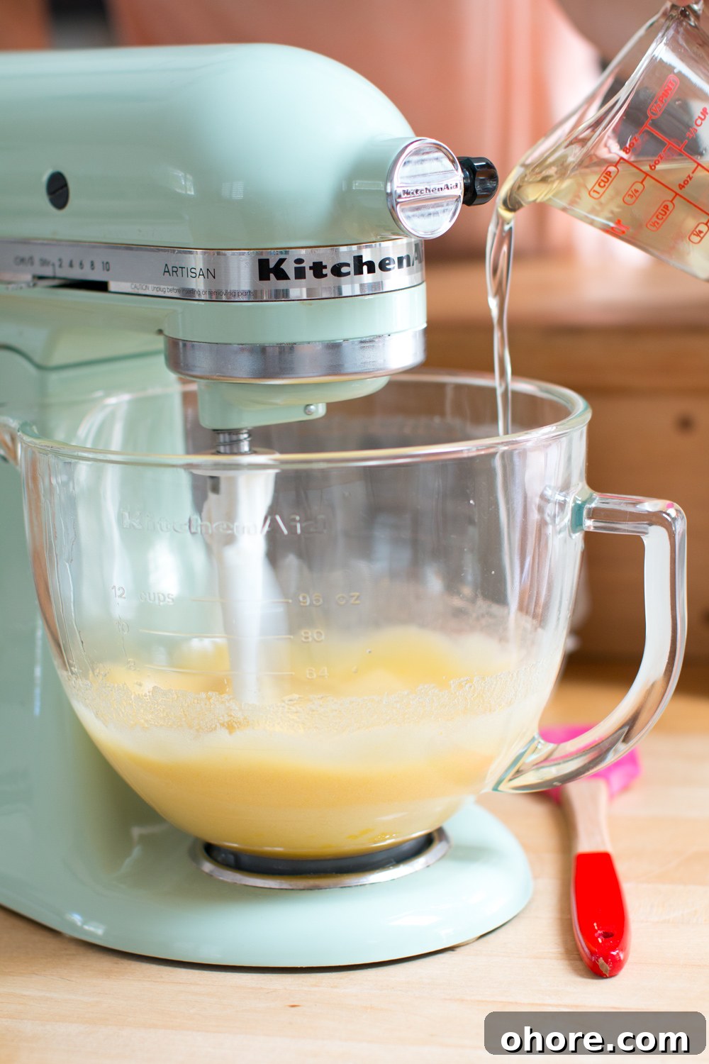 pouring coconut oil into the cupcake batter