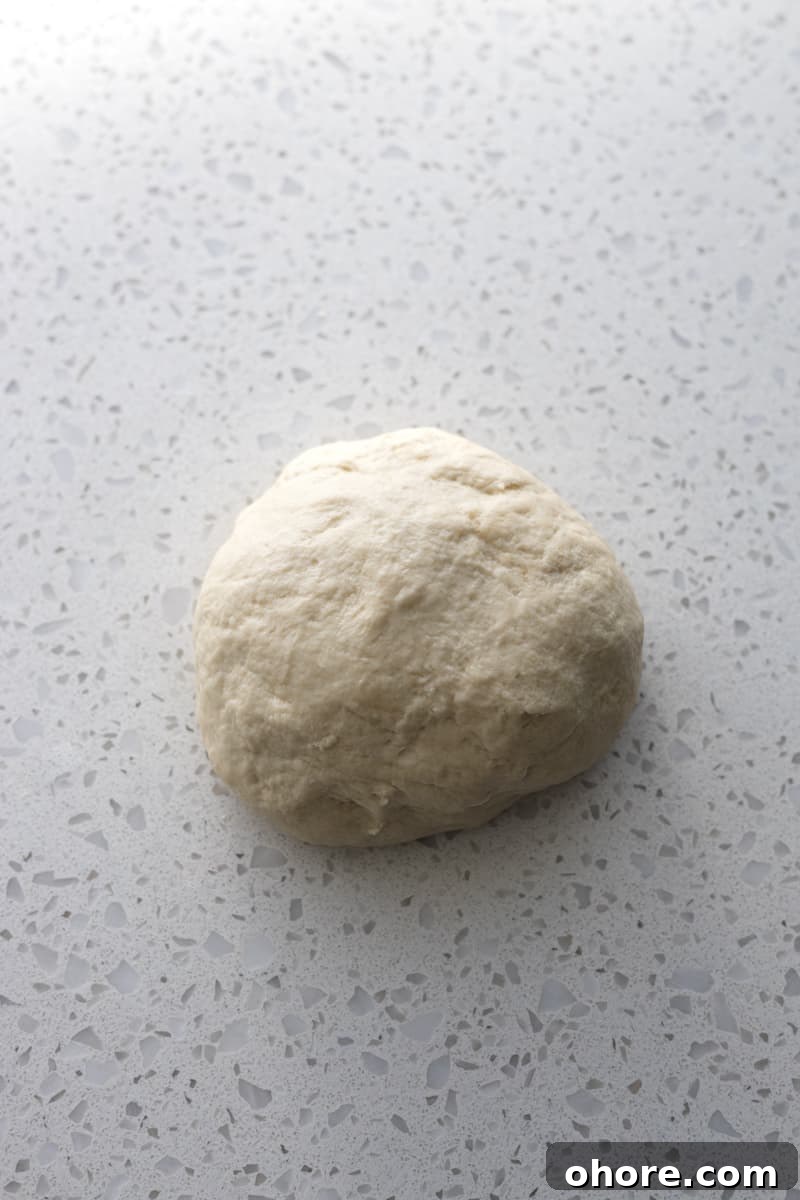 Crispy Sourdough Discard Crackers Recipe for Zero-Waste Snacking 5 Dough on a white stone work surface.