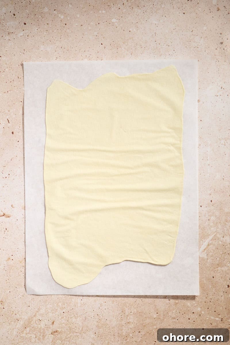 Crispy Sourdough Discard Crackers Recipe for Zero-Waste Snacking 7 Dough rolled thin on a piece of parchment paper.