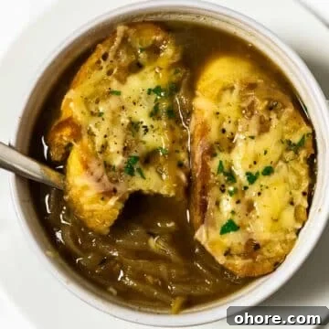 a close up view of a bowl of french onion soup with a spoon in it.