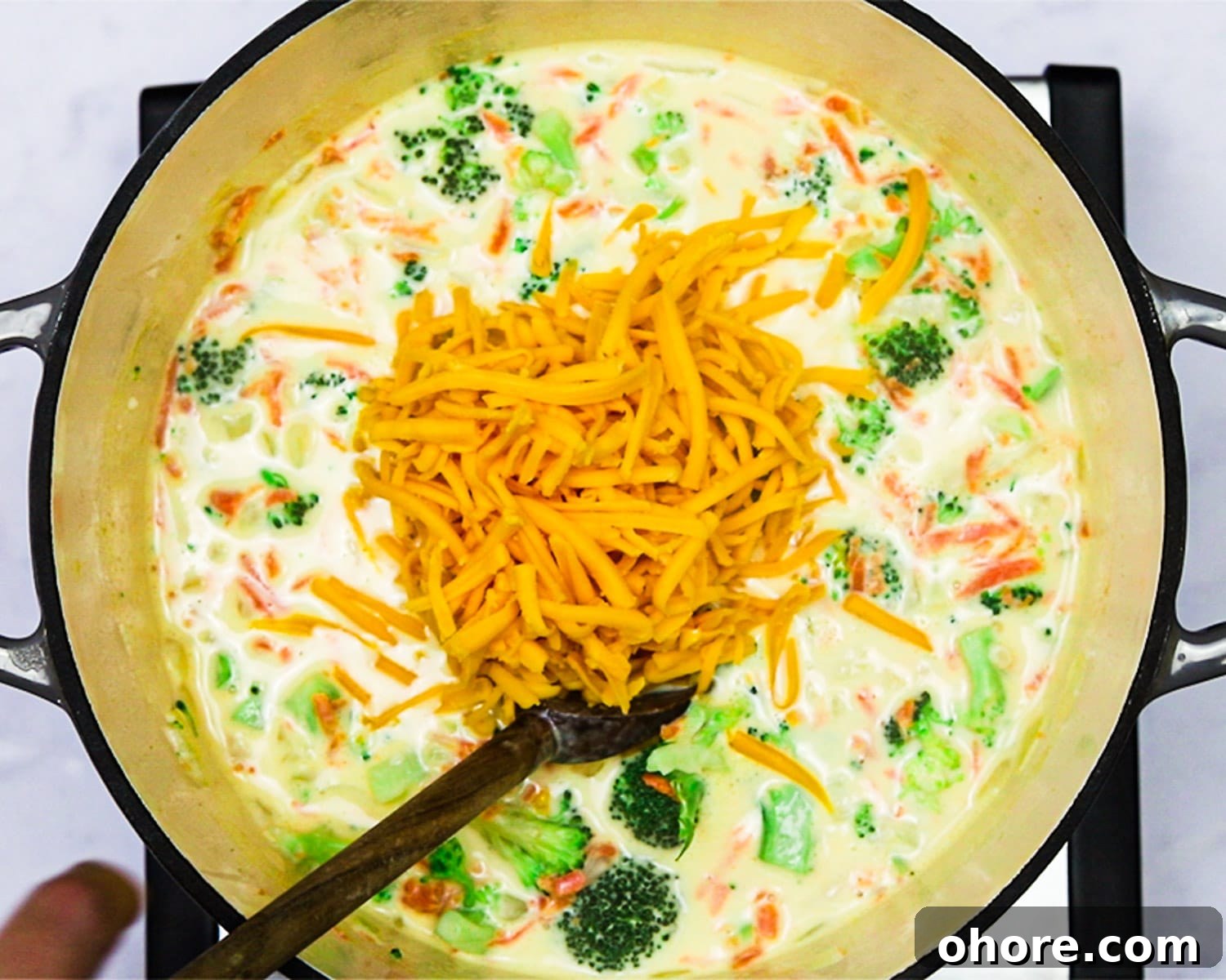 Creamy Broccoli Cheddar Soup Recipe for Cozy Comfort Meal 8 Adding cheese to broccoli cheddar soup.