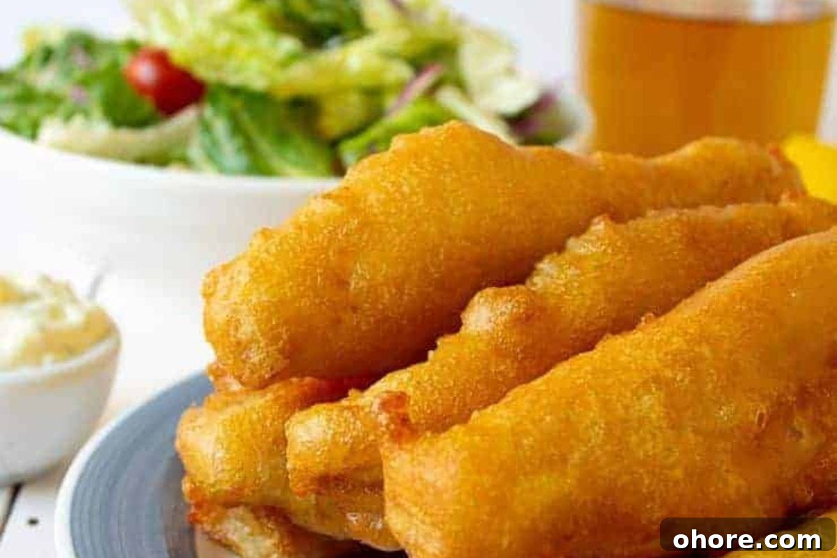 12 Spectacular Seafood Dinners for Meat-Free Weeknight Meals 10 A close-up of golden battered fish sticks served with a side of fresh salad and a small bowl of tartar sauce.