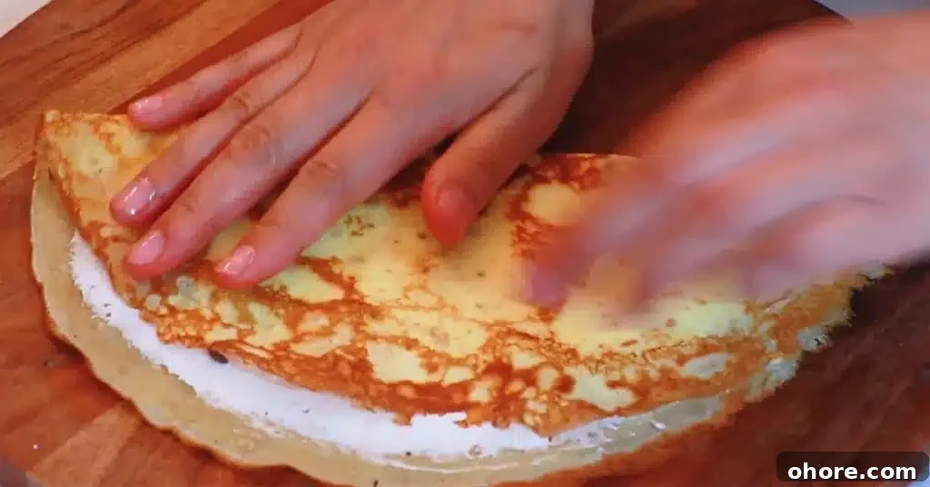 folding a crepe to make a crepe dessert