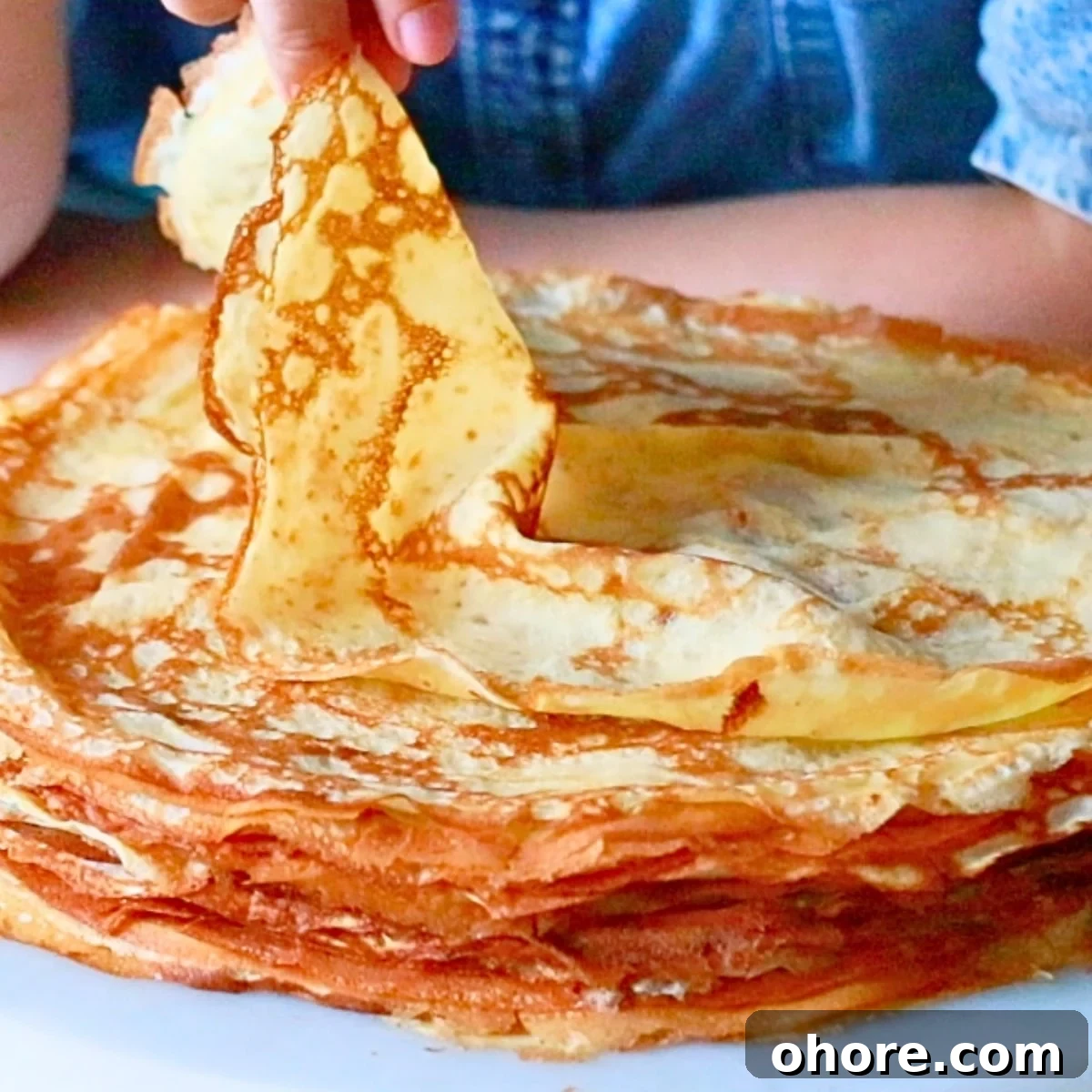 taking a piece of homemade crepe by hand