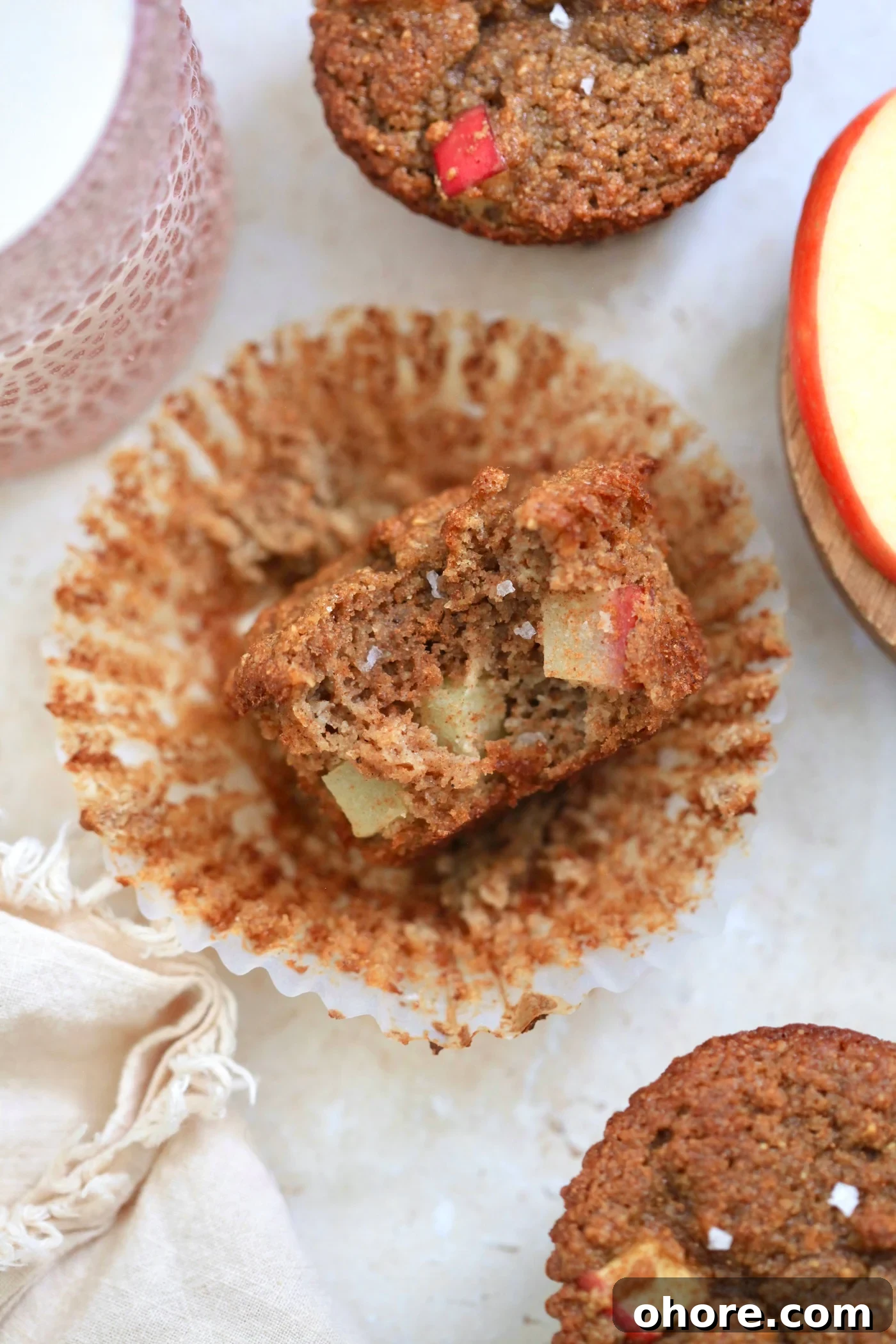 Almond Flour Apple Muffins: Fluffy, Gluten-Free Recipe 8 muffin with apple and bite taken out in wrapper