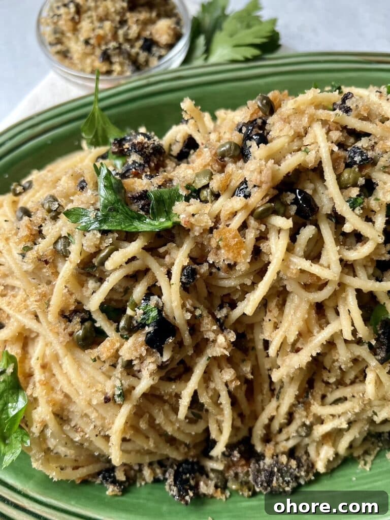St. Joseph’s Spaghetti with Anchovies and Crispy Breadcrumbs 6 St Joseph's Pasta in green platter with parsley garnish and small bowl of breadcrumbs in background.