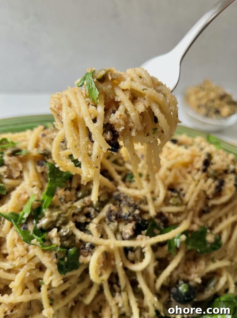St. Joseph’s Spaghetti with Anchovies and Crispy Breadcrumbs 7 Close up of spaghetti with mollica on fork.