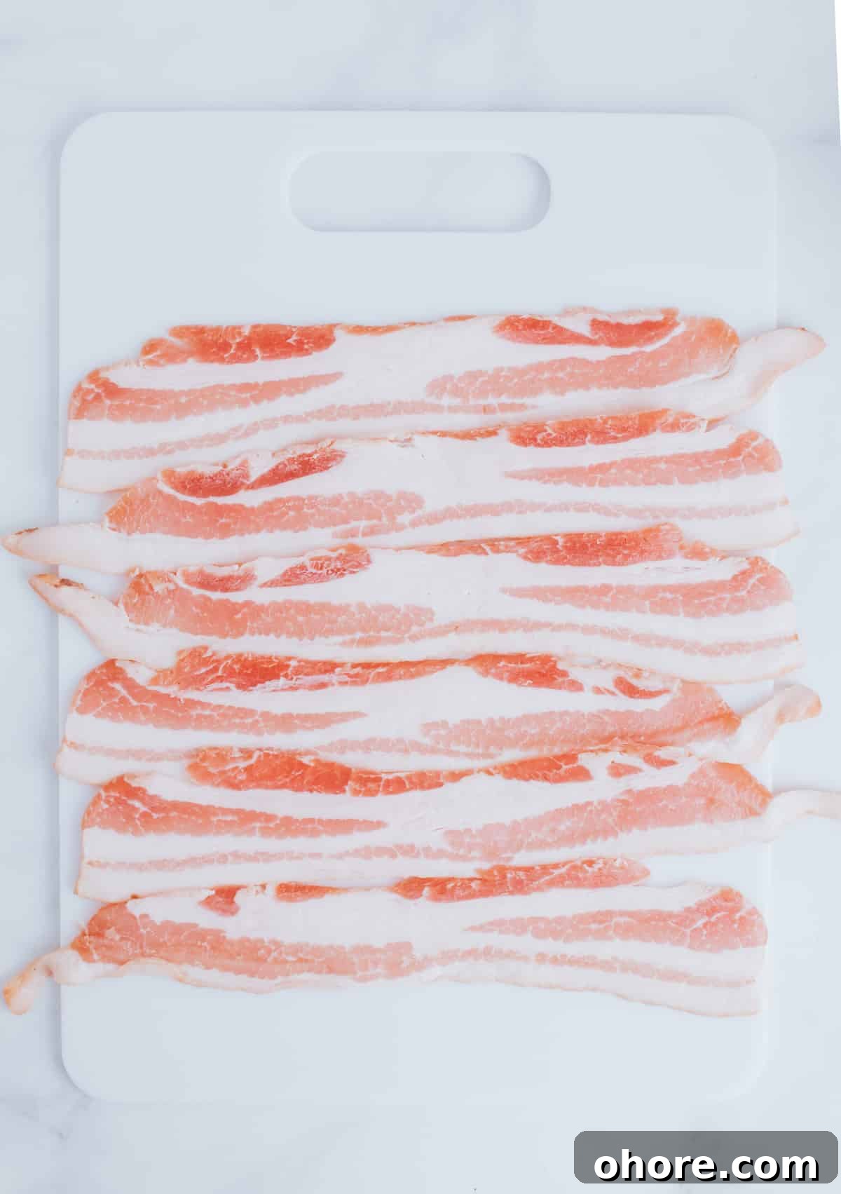 strips of bacon on a cutting board