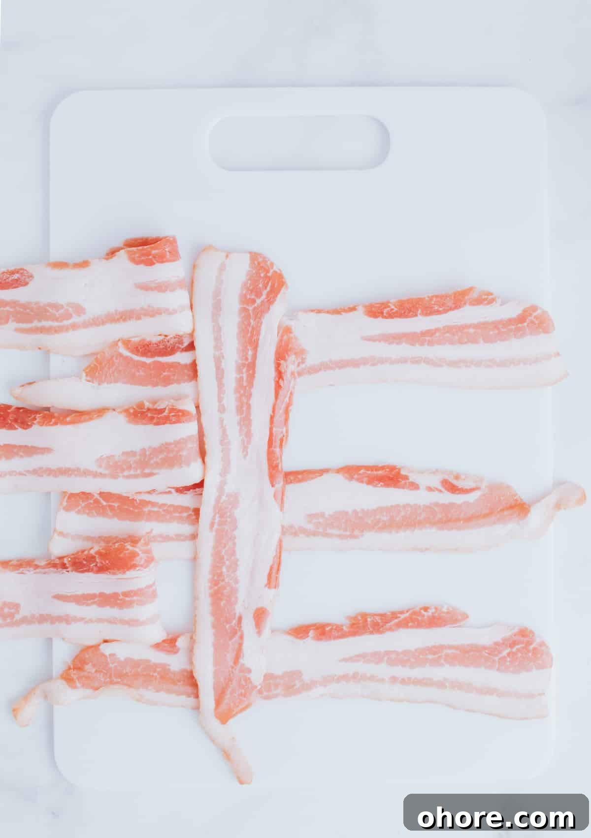 folding strips of bacon on a cutting board