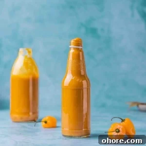 Sweet and Spicy Mango Habanero Sauce for wings in a bottle on a flat surface.