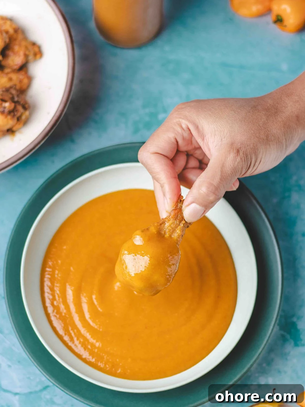 Mango Habanero Wing Sauce: Sweet, Spicy, Tangy Recipe 4 Dipping chicken wings into mango habanero sauce.