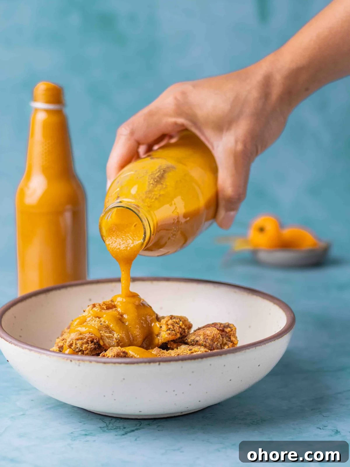 Mango Habanero Wing Sauce: Sweet, Spicy, Tangy Recipe 8 Pouring the hot sauce over some wings.