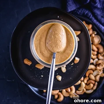 cashew pasta sauce in a mason jar scooped with a spoon.