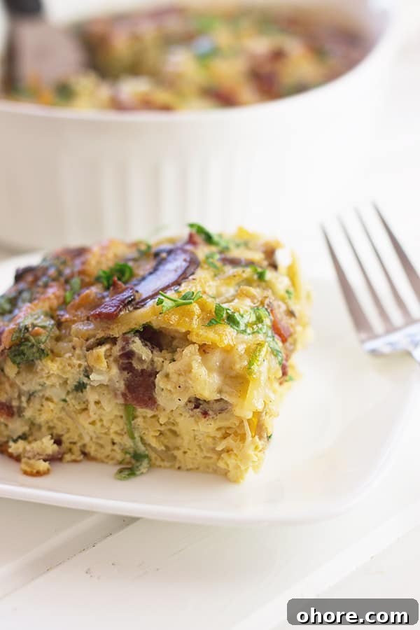 a close up photo of a slice of bacon, mushroom and spinach breakfast casserole