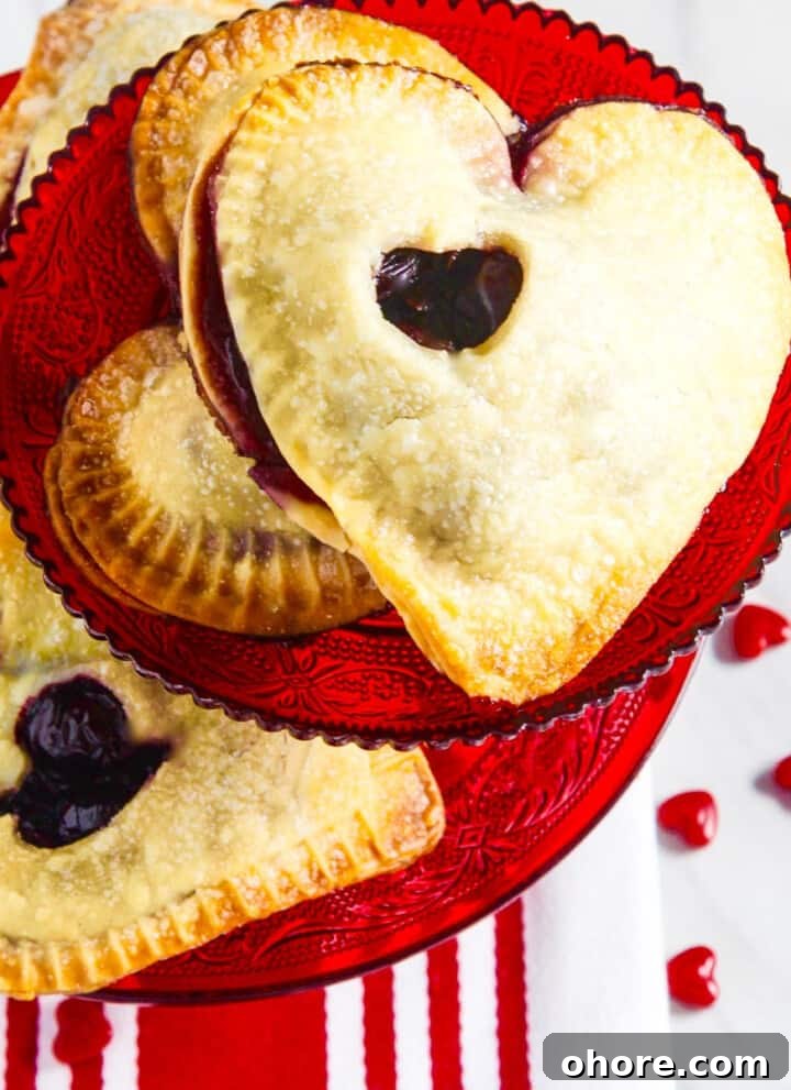 A red cookie plate filled with heart shaped chocolate hand pies.